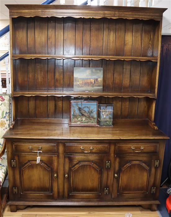 A reproduction oak dresser, with boarded plate rack W.154cm